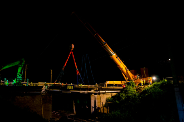 Kran, Porr, Baustelle mit Arbeitern in der Nacht